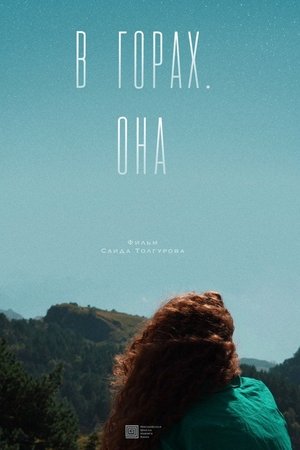 В горах. Она